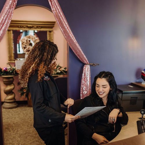 Friendly front receptionists working together on a computer.